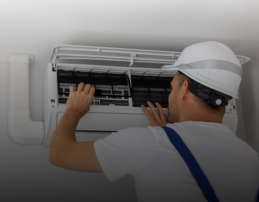 Technician repairing ceiling air conditioning unit.